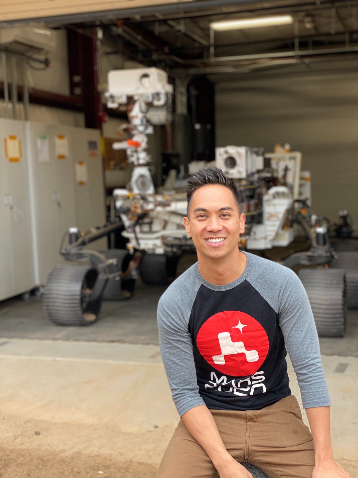Gregory Villar in front of a Mars rover test vehicle at JPL